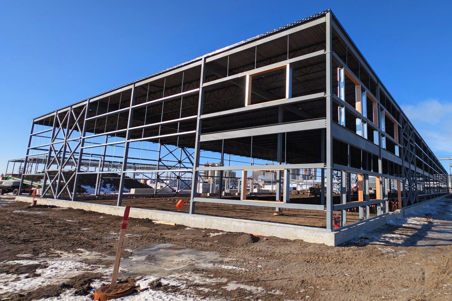 Structural steel frame of a new Edmonton-area industrial building under construction on a clear winter day