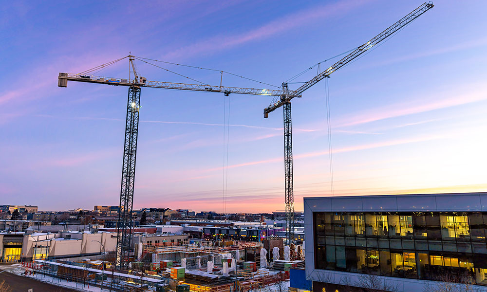 Cranes above the School of Business construction site at sunset